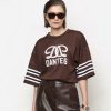 Dante6 Dax Bow Detail Logo Tee in donkerbruin, oversized dames T-shirt met sportieve logodetails en strikdetail op de rug.