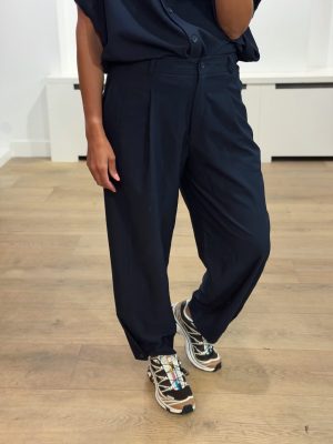 AÍMÉE THE LABEL ColombiaW6 Pants in Marine, donkerblauwe wijde damespantalon met hoge taille, plooidetails en knoopdetails onderaan de pijpen.