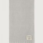 American Vintage Zinaco sjaal ZI20AH26GRICHL in Gris Chiné Noir, lichtgrijze gemêleerde gebreide sjaal met franjes en American Vintage logolabel.